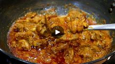 a pan filled with meat and sauce being stirred by a ladle on the stove