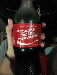 a woman holding up a bottle of coke with the words thanks for the memories on it