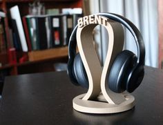 headphones are sitting on top of a wooden stand in front of a bookshelf