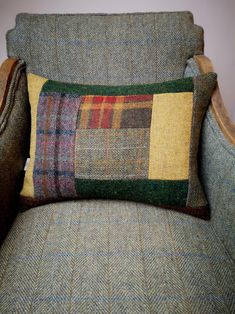 a plaid pillow sitting on top of a green chair