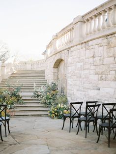 there are many chairs and tables outside by the stairs