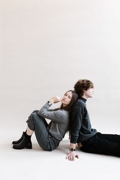 a young man and woman sitting on the ground