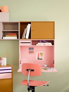 a pink desk chair sitting in front of a book shelf