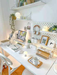 a white desk topped with a computer monitor and keyboard