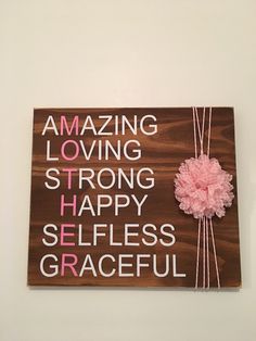 a wooden sign that says amazing loving strong happy selfless graceful on the wall