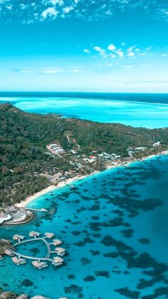 an aerial view of a tropical island with boats in the water and blue skies above