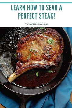 a piece of meat is cooking in a frying pan on a blue cloth next to a wooden table