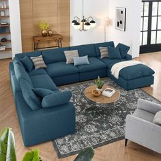 a living room filled with blue couches and pillows on top of a wooden floor