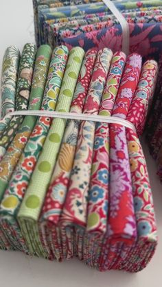 many different colored fabrics are stacked on top of each other