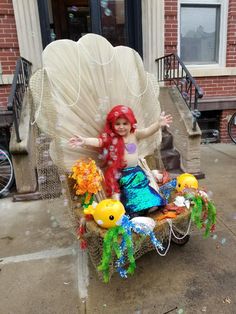 a little mermaid sitting on top of a chair