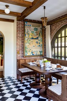 a dining room with a checkered floor and brick walls