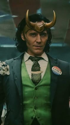 a man in a suit with horns on his head wearing a green vest and tie