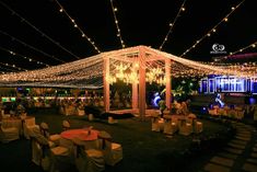 an outdoor wedding venue decorated with lights and decorations