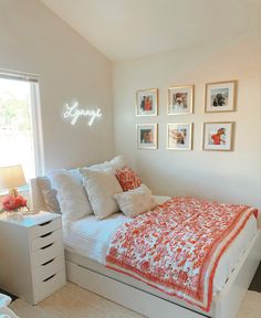 a bedroom with white walls and pictures on the wall above the bed that says simply