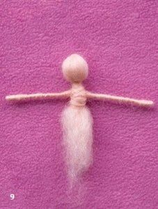 a needled doll is posed on a pink background with white yarn and thread in the shape of a ball