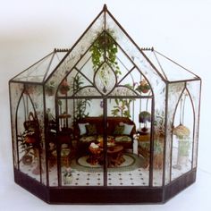 a glass house with plants and furniture in it's centerpiece on a white background