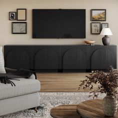 a living room with a large flat screen tv mounted on the wall above it's entertainment center