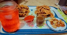 a tray with some food and drinks on it next to a glass bottle filled with liquid