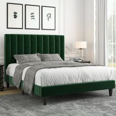 a bed with green velvet headboard and foot board in a white walled bedroom area