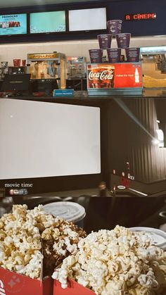 two boxes filled with popcorn sitting on top of a table next to a computer monitor