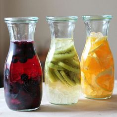 three glass vases filled with different types of fruit