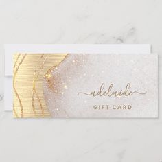 a white and gold gift card with glitter