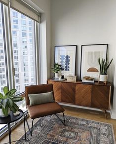 a living room filled with furniture and large windows next to a tall window sill