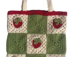 a crocheted bag with apples on the front and bottom, in red, white and green