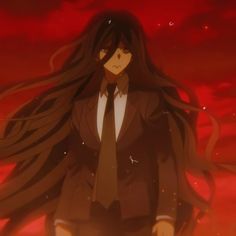 a woman with long black hair wearing a suit and tie standing in front of a red sky