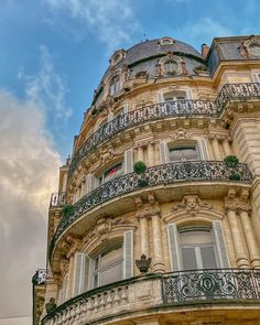 an ornate building with balconies and balcony railings on a cloudy day in paris