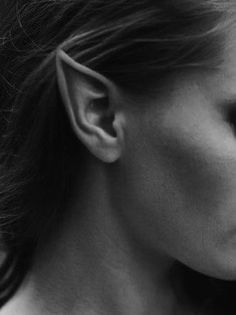 black and white photograph of a woman's face with ear piercings on her ears