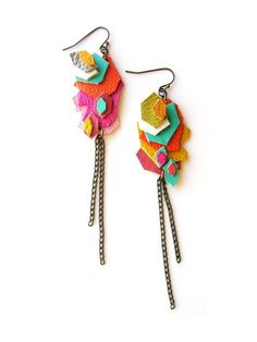 two pairs of colorful earrings with chains hanging from the side on a white background,