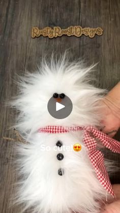 a snowman stuffed animal being held by someone