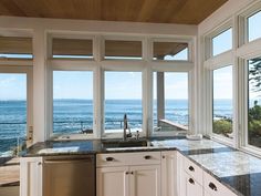 a kitchen with large windows overlooking the ocean