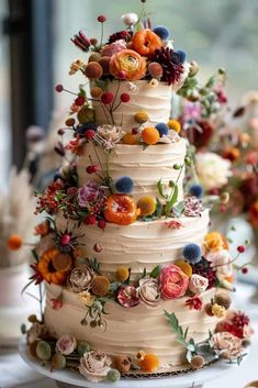 a wedding cake decorated with flowers and berries