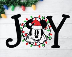 the word joy with mickey mouse wearing a santa hat and lights around it is surrounded by christmas decorations