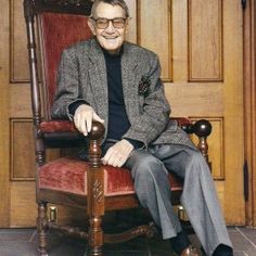 an older man sitting in a red chair