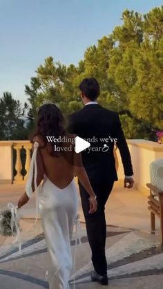 the bride and groom are walking down the sidewalk