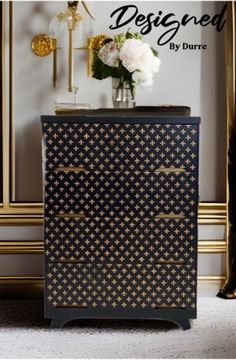 a black and gold dresser with flowers on top