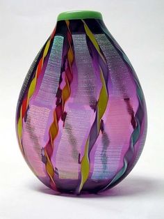 a colorful glass vase sitting on top of a white table