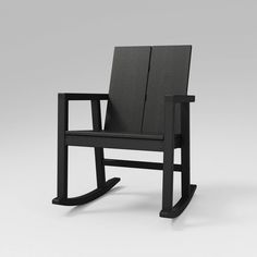 a black rocking chair sitting on top of a white floor