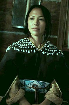 a woman in an ethnic dress poses for the camera