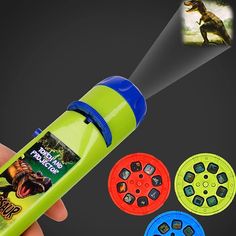 a hand holding a green flashlight with four different colored circles around it and an image of a dinosaur