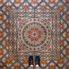 a person standing in front of a tiled floor with their feet up on the ground