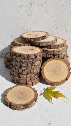 several pieces of wood sitting on top of each other next to a maple tree leaf