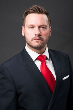 a man in a suit and red tie