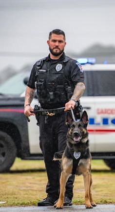 a police officer is walking his dog in the rain with an alert look on his face