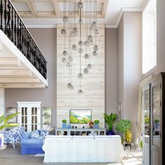 a living room filled with furniture and a large chandelier hanging from the ceiling