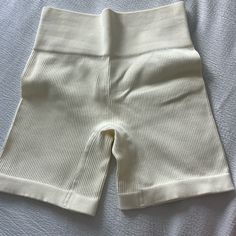 a pair of white shorts laying on top of a bed