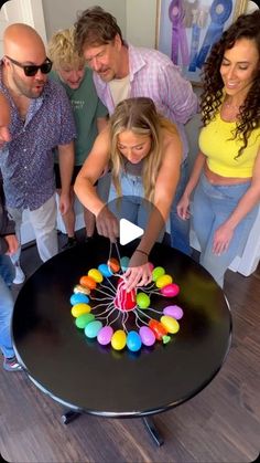 a group of people standing around a black table